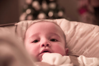 Portrait of cute baby lying on bed