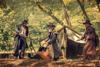 People standing by plants in forest