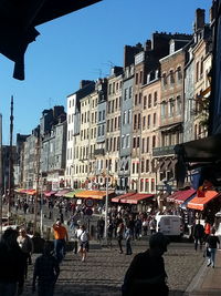 People on street amidst buildings in city