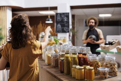 Portrait of woman drinking glass jars at restaurant