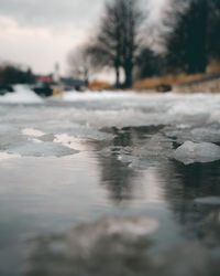 Surface level of frozen river against sky