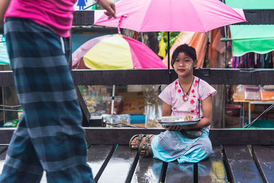 Woman holding umbrella while standing in rain