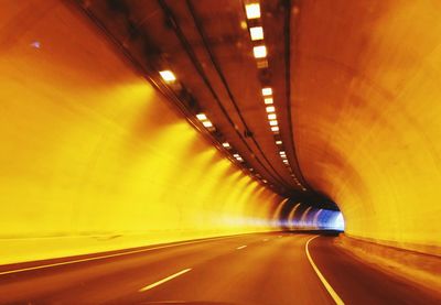 Empty road in illuminated tunnel