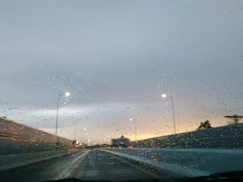 Road seen through wet windshield during rainy season