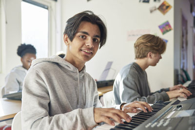 Teenagers attending keyboard lesson