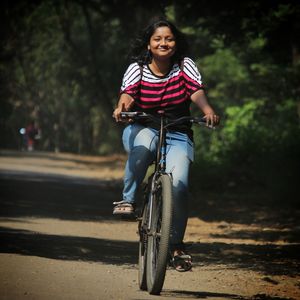 Portrait of man riding bicycle on road