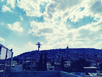 View of cityscape against cloudy sky