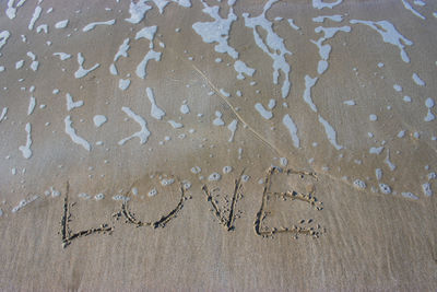 High angle view of text on sand at beach