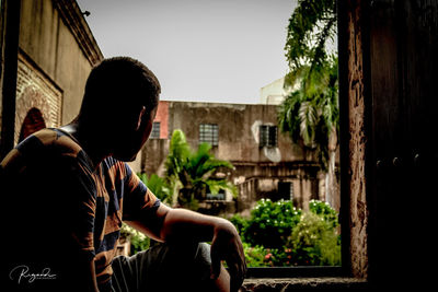 Rear view of man sitting on seat against sky