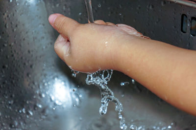 Close-up of wet hand in water