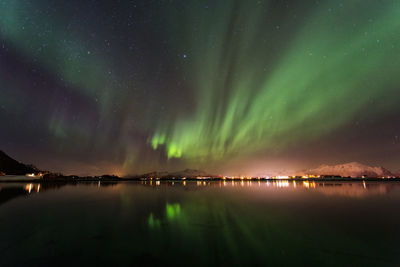 Scenic view of sea against aurora borealis at night