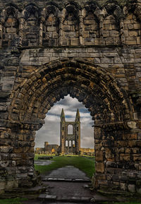 View of old ruin building on field against sky