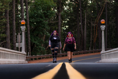 Rear view of woman walking on road