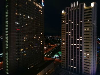 Illuminated cityscape against sky at night