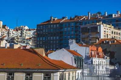 Houses in town against clear blue sky