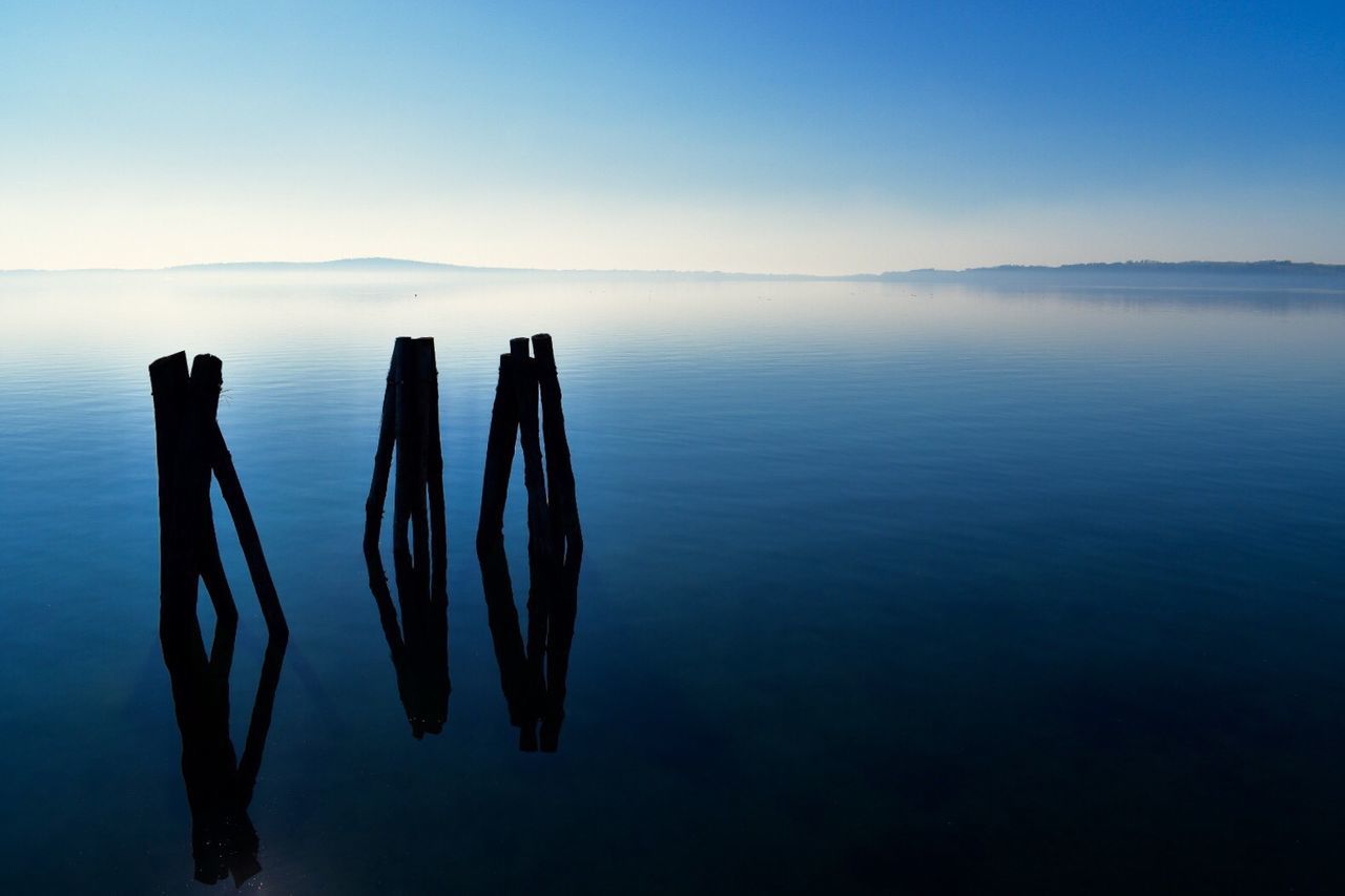 water, tranquility, scenics - nature, sky, tranquil scene, beauty in nature, sea, no people, nature, reflection, waterfront, blue, non-urban scene, post, idyllic, horizon, horizon over water, wooden post, outdoors