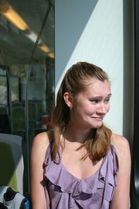 Smiling woman looking away while sitting in bus