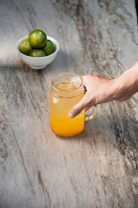 Cropped hand of person holding bell pepper on table