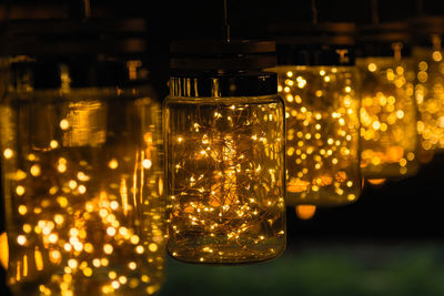 Close-up of illuminated light bulb in jars