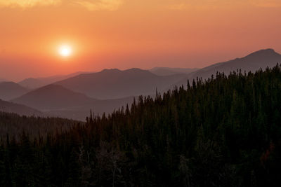 Scenic view of mountains against orange sky