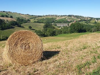 Hay bales on field against sky