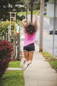 Rear view of woman walking on footpath