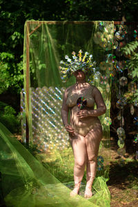 Portrait a woman in a reflective mask in a beige bikini against the background of a cd / dvd case