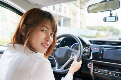 Portrait of smiling woman in car