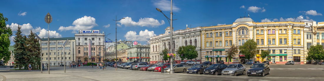 Panoramic view of city street and buildings against sky