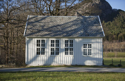 Exterior of ole building by field against sky