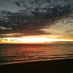 View of sea against cloudy sky during sunset