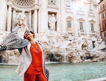 Statue of woman standing in front of building