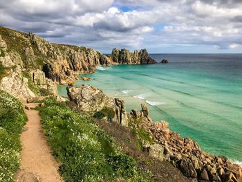 Scenic view of sea by cliff against sky