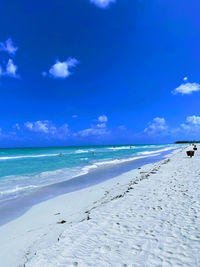 Scenic view of beach against blue sky