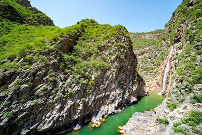 Scenic view of rocks and trees against sky