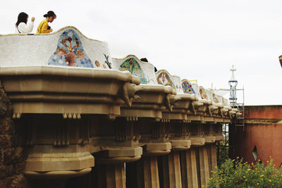 Low angle view of sculpture by building against clear sky