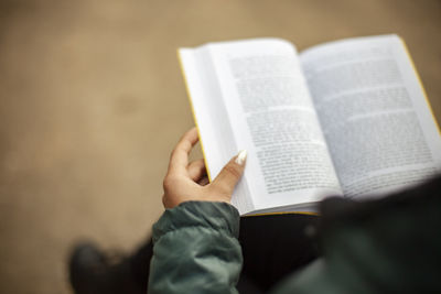 Midsection of person holding book