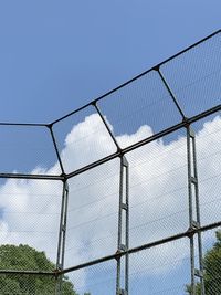 Low angle view of chainlink fence against clear blue sky