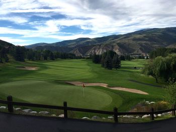 Scenic view of golf course against sky