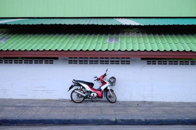 Scooter parked against brick wall