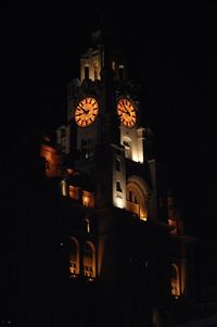 Low angle view of illuminated building against sky at night