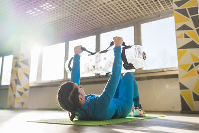 Side view of woman exercising in gym