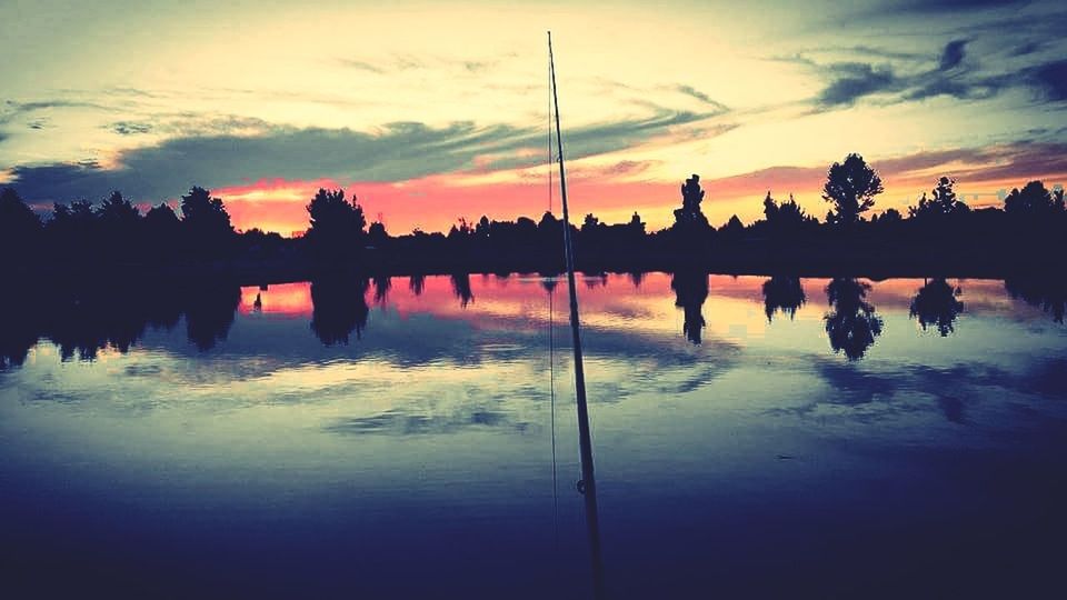 SILHOUETTE PEOPLE IN WATER AGAINST SKY DURING SUNSET