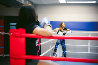 Portrait of young woman with friend standing in ring