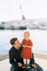 Full length of boy sitting on shore