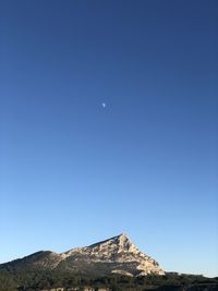 Low angle view of moon against clear blue sky