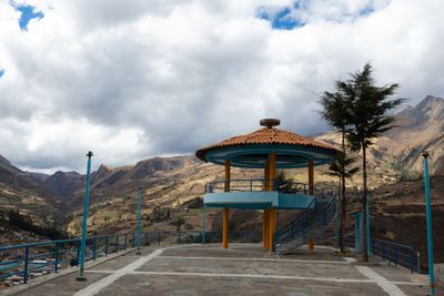 Gazebo by mountains against sky