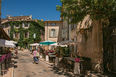 People walking on street amidst buildings in city