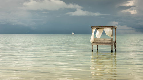 Lifeguard hut in sea against sky