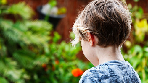 Rear view of boy standing outdoors